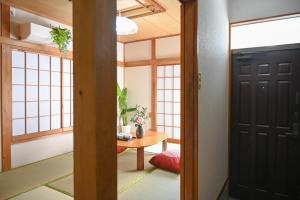 eine Tür, die in ein Zimmer mit einem Tisch führt in der Unterkunft Asakusa Ginza direct access to the airport in Tokio
