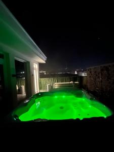 弗洛雷什蒂HexHouse Luxury的夜晚房间里的绿色浴缸