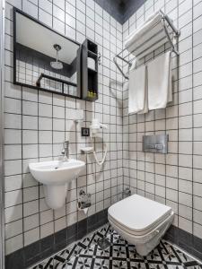 a white tiled bathroom with a sink and a toilet at The Big Urban Stay in Istanbul +27 photos