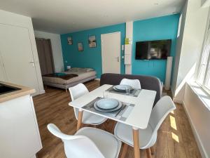 a living room with a white table and chairs at Studio Ô Bleu - entre St Malo et Cancale in Saint-Méloir-des-Ondes