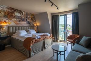 a hotel room with a bed and a couch at Scandic Arvika in Arvika +72 photos