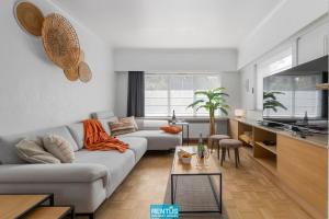 a living room with a couch and a table at Coppietershof - spacious home with garden near historic Bruges in Bruges