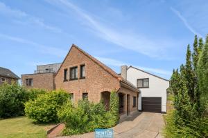 a brick house with a garage at Coppietershof - spacious home with garden near historic Bruges in Bruges