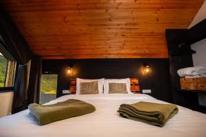 una camera da letto con un letto grande con due asciugamani sopra di Mountain Escape Resort a Zărneşti