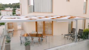 a balcony with a table and chairs on a building at A'More Preko in Preko