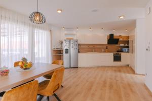 a kitchen and dining room with a table and chairs at A'More Preko in Preko +15 photos