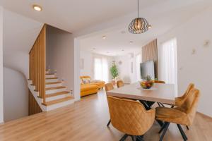 a dining room and living room with a table and chairs at A'More Preko in Preko