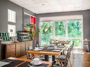 a dining room with tables and chairs and windows at Hotel Speyer am Technik Museum in Speyer