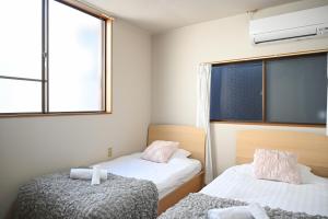 a small room with two beds and a window at Asakusa Ginza direct access to the airport in Tokyo