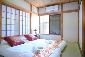 a bedroom with two beds in a room with windows at Asakusa Ginza direct access to the airport in Tokyo +55 photos