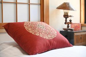 a red pillow sitting on a bed next to a lamp at Asakusa Ginza direct access to the airport in Tokyo