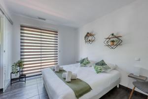a white bedroom with a large bed and a window at Lou Souvarel - Maison au calme proche calanques in Roquefort-la-Bédoule +20 photos