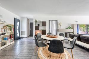 a living room with a table and chairs and a couch at Lou Souvarel - Maison au calme proche calanques in Roquefort-la-Bédoule