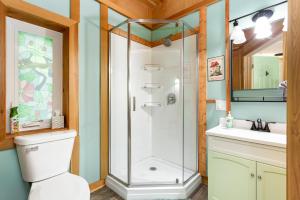 a bathroom with a shower and a toilet and a sink at Frog Hollow at Hocking Vacations in Logan +22 photos