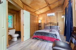 a bedroom with a bed and a toilet in a room at Frog Hollow at Hocking Vacations in Logan