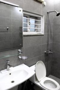 a bathroom with a toilet and a sink and a mirror at Islamabad Elite Suites in Islamabad