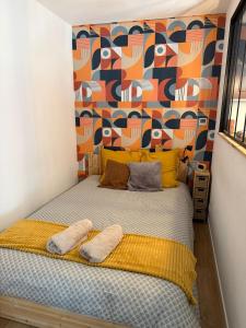 a bedroom with a bed with a colorful wall at Maison Sorbier - Appartement 2 in Nevers