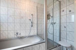 a bathroom with a shower and a tub at Ferienhaus Svea in Cuxhaven +32 photos