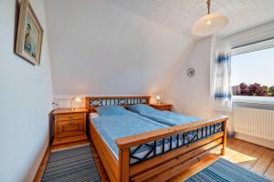 a bedroom with a wooden bed and a window at Ferienhaus Svea in Cuxhaven