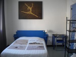 a bedroom with a bed with a blue head board at L 'Acropole in Nissan-lez-Enserune