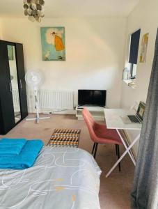 a bedroom with a bed and a desk with a laptop at Atom, Large 4 to 5 Bed House in East London, Sleeps 12, Garden, Parking, ideal for Contractors, Large Groups, Travellers in Barking