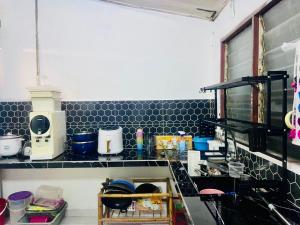 a kitchen with a counter top with many items on it at imani homestay taman ira kangar perlis in Kangar