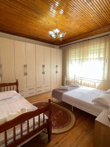 a bedroom with two beds and a wooden ceiling at Shkodra Green Heart in Shkodër
