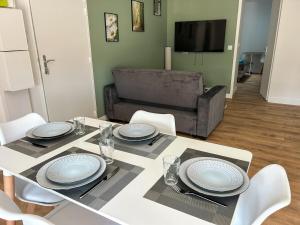 un comedor con una mesa con platos. en L'Échappée Verte - appartement 1 chambre, en Saint-Méloir-des-Ondes