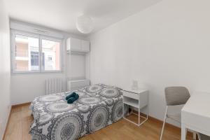 Un dormitorio con una cama y un escritorio y una ventana. en Grand appartement Rouen Free Parking Privé Gratuit, en Rouen 7 fotos más
