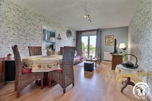 a living room with a table and chairs at Le haut de breizh in Sens-de-Bretagne