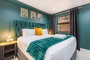 ダーバンにあるThe Green Diamond - Stylish and Spacious Umhlanga Ridge Apartment - Rooftop Pool and King Bedsの緑のヘッドボードが付いた大きなベッドのある寝室