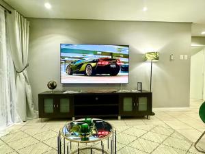 ダーバンにあるThe Green Diamond - Stylish and Spacious Umhlanga Ridge Apartment - Rooftop Pool and King Bedsの壁に薄型テレビが取り付けられたリビングルーム +46枚の写真