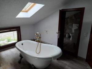 a white bath tub in a bathroom with a skylight at Lotru Relax Chalet in Malaia +26 photos