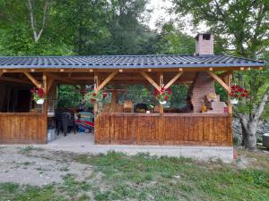 a wooden gazebo with a black roof at Lotru Relax Chalet in Malaia