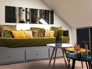 a living room with a green couch and a table at appartement cosy in Saint-James