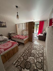 1 dormitorio con 2 camas y alfombra en el suelo en Летняя сказка, en Cholpon-Ata