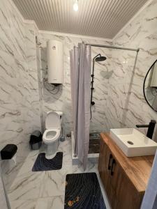 un baño con inodoro y lavabo en Летняя сказка, en Cholpon-Ata