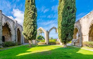 un antiguo edificio de piedra con árboles en un patio en Maestral Mansion, en Kyrenia