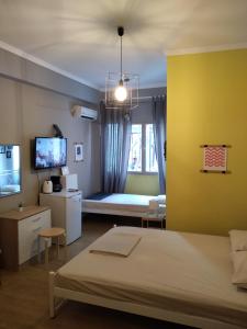 a bedroom with a large bed and a yellow wall at Plaka - Acropolis comfort rooms in Athens