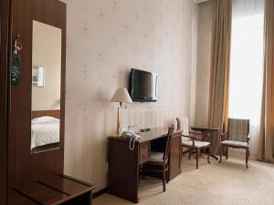 a hotel room with a desk and a bed at Continental Hotel in Odesa