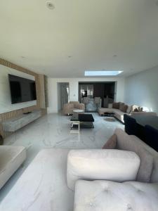 a living room with couches and a tv on the wall at Cosy 4 bedroom house in borehamwood in Borehamwood