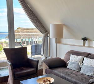 シャルボイツにあるMaris Ferienwohnung Nr 47 OG mit Balkon und Meerblickのリビングルーム(ソファ、椅子、窓付)