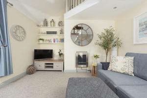 ein Wohnzimmer mit Sofa und Fernseher in der Unterkunft Bessie Ellens Cottage in Fowey