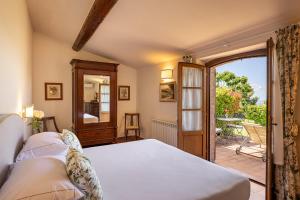 a bedroom with a bed and a door to a patio at Wine Relais In Montecucco - ColleMassari Hospitality in Cinigiano +110 photos