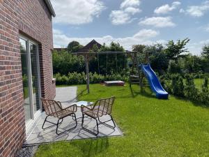 ブットヤーディンゲンにあるFerienhaus Meerweh mit Saunaの庭(椅子2脚、遊び場付)