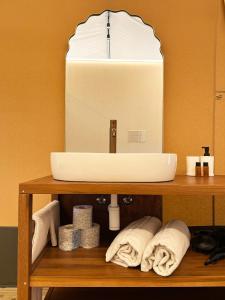 a bathroom with a sink and towels on a shelf at Riza Eco Tents in San Vito lo Capo