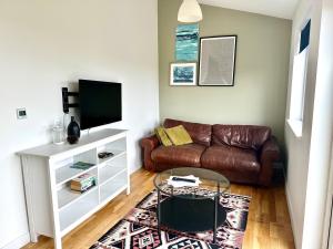 佩伦波斯St George's Hotel的客厅配有真皮沙发和电视