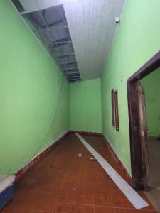 an empty room with green walls and a wooden floor at Residential House in Juigalpa