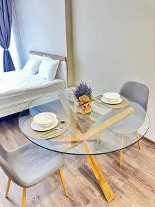 a glass table with two chairs and a couch at Chantrer in Burgas City