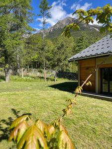 a house in a field with a mountain in the background at le chalet de st Anne in Jausiers